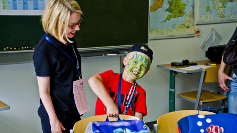 Als Monster geschminktes Kind mit Lehrerin