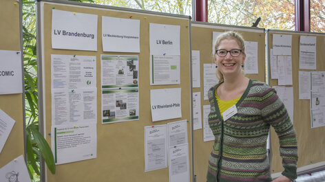 Frau steht vor Plakatinfowänden