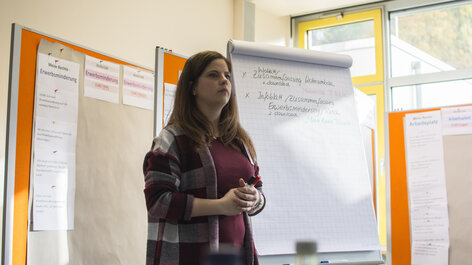 Frau steht vor Flipchart